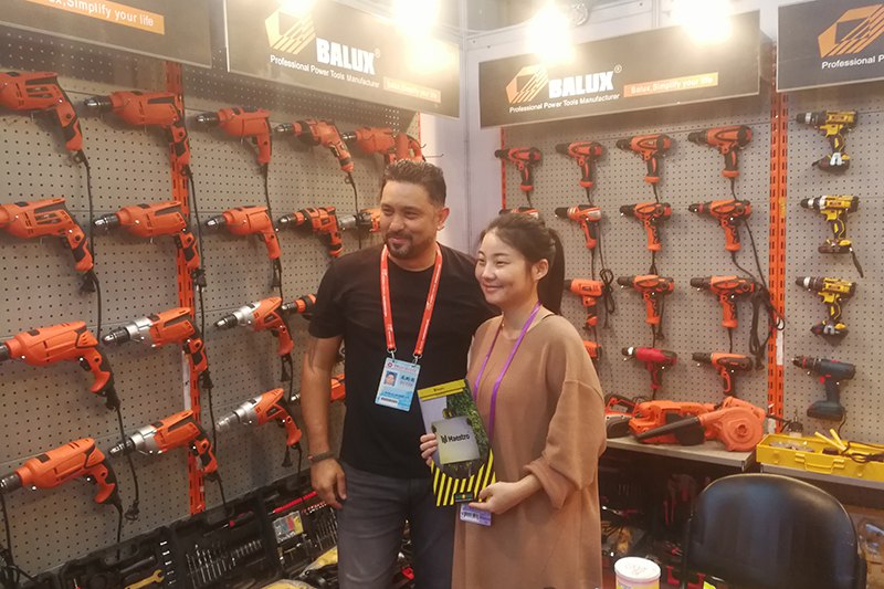 BALUX exhibition booth with visitors and a wall of drills
