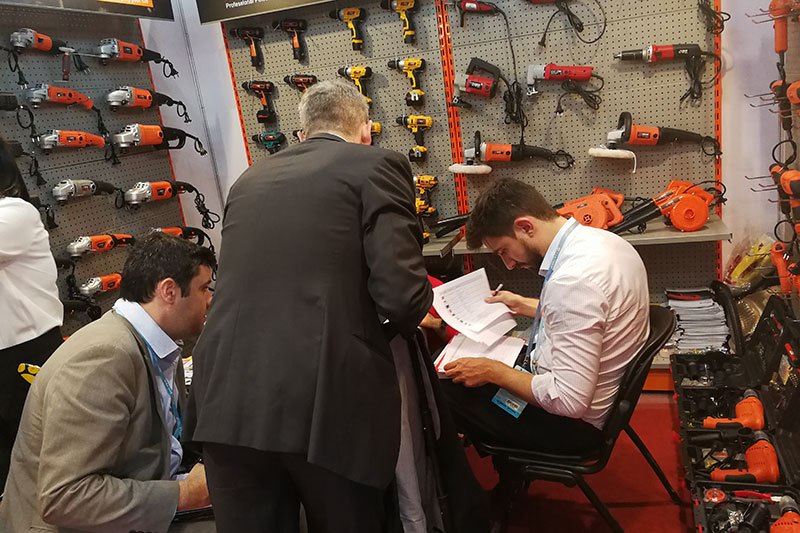 Customers reviewing the BALUX catalogue at the booth
