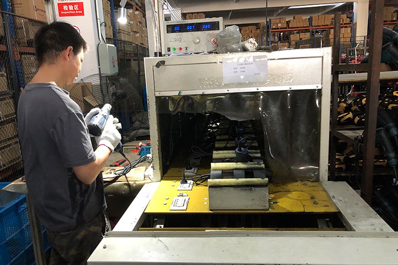 Technician testing a power tool on a test bench